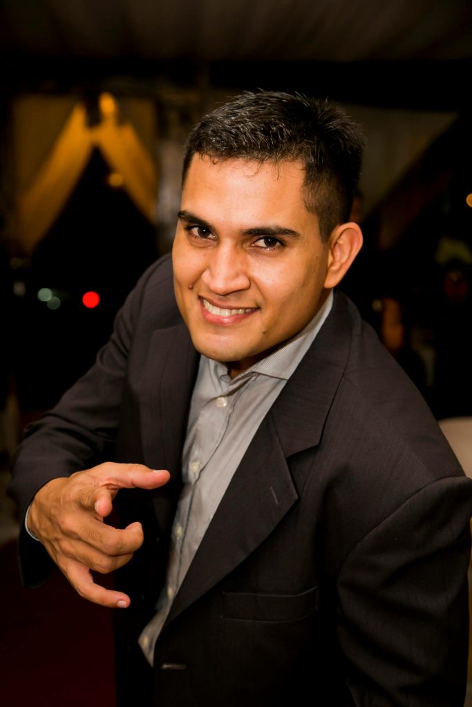 pexels-photo-50855-50855 Portrait of a confident, smiling businessman in a formal suit pointing directly at the camera indoors.